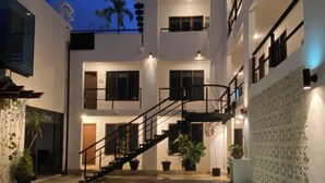 Ein modernes Gebäude mit Pool, Treppe und Topfpflanzen.