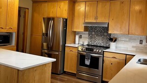 Una cocina moderna con armarios de madera, electrodomésticos de acero inoxidable y un tragaluz.