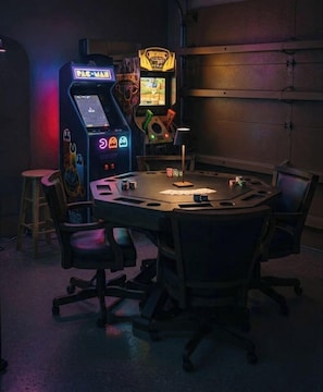 Kokoushuone, jossa on pyöreä pöytä, tuoleja ja Pac-Man-peliautomaatti.