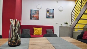 Un salon moderne avec un canapé rouge, une table basse en bois et un escalier jaune.