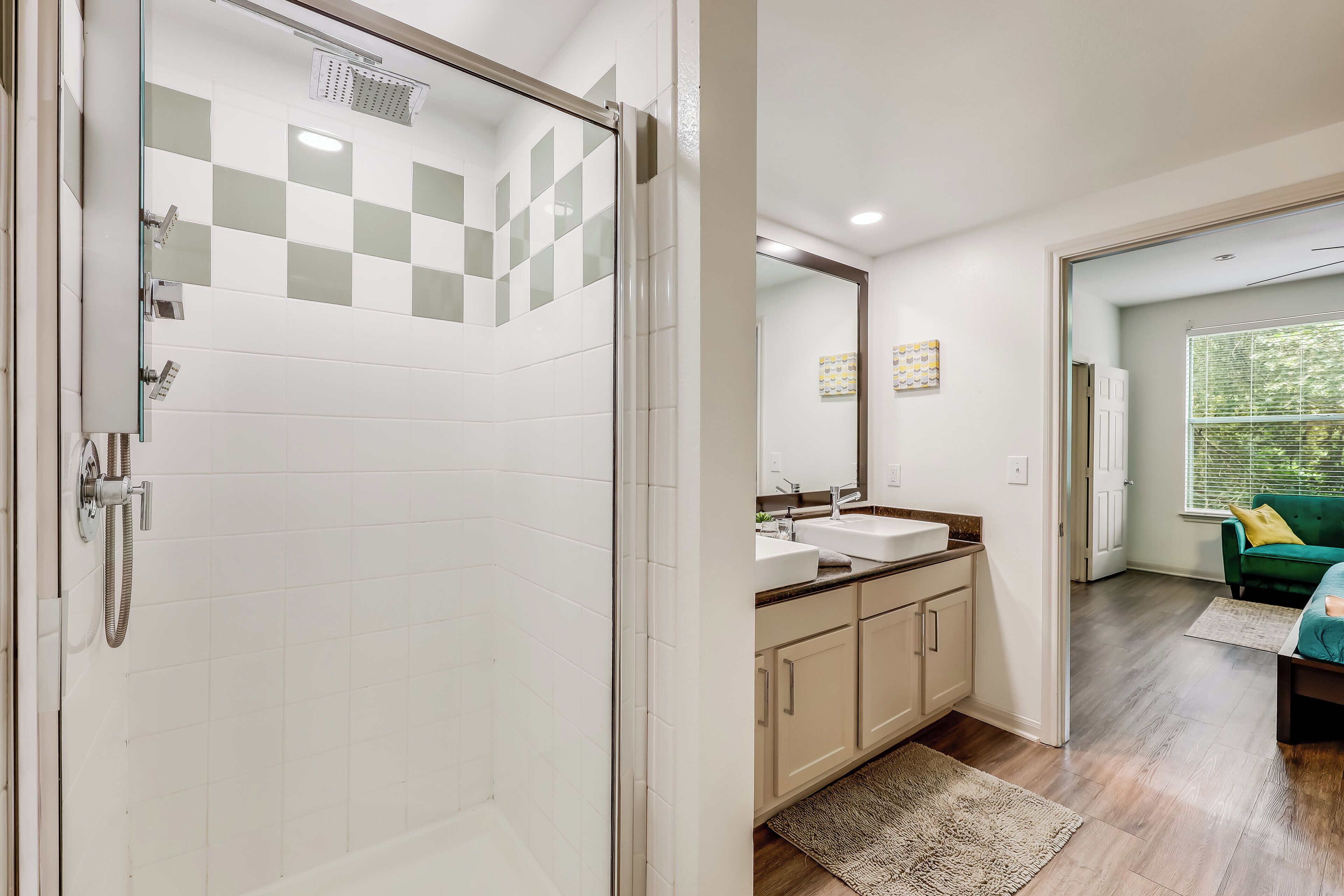 A modern bathroom with a glass shower enclosure, a sink, and a mirror.