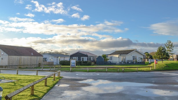 A residential area with houses, a grassy lawn, and a paved road. - 2 bedroom accommodation in Wilsthorpe (Wilsthorpe)