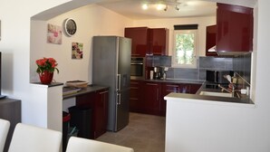 A modern kitchen with stainless steel appliances, dark cabinetry, and a window providing natural light.