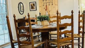 Un coin repas avec une table et des chaises en bois, un lustre et un buffet en bois.