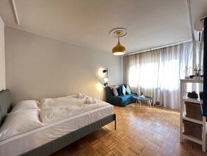 Ein Hotelzimmer mit einem Bett, einem Sofa, einem kleinen Tisch und einer Deckenleuchte.