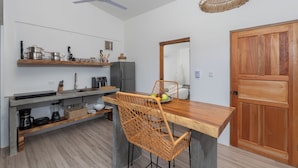 Una cocina moderna con encimera de madera, un lavamanos integrado y un ventilador de techo.