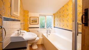 A bathroom with a bathtub, two sinks, and a toilet. There is a window with a view of greenery outside. - Mouse Manor - pet friendly, Longborough near Stow-on-the-Wold (Longborough)