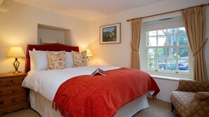 A bedroom with a bed, a nightstand, a dresser, a window with curtains, and a framed picture on the wall. - Mouse Manor - pet friendly, Longborough near Stow-on-the-Wold (Longborough)