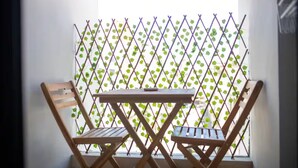 A small balcony with a wooden table and two wooden chairs. - Studio in the heart of Casablanca (Casablanca)