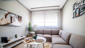 A modern living room with a beige sofa, a white coffee table, and artwork on the walls. - Studio in the heart of Casablanca (Casablanca)