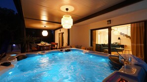 A hot tub with a digital control panel, a dining area with a table and chairs, and a staircase leading to an upper level. - Villa Fusion with Pool (Sukošan)