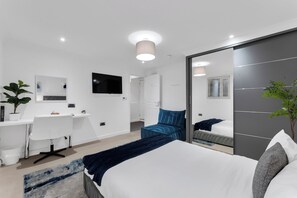 Una habitación de hotel moderna con cama, escritorio y zona de estar.