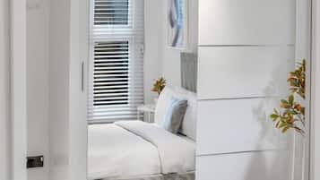 2 habitaciones, escritorio y tabla de planchar con plancha