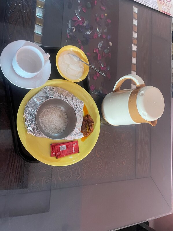Un plateau avec une assiette contenant du riz, un paquet de collations et un petit bol de yaourt.