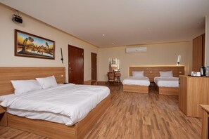 A hotel room with two beds, a desk, and a chair. - Rosetta pyramids inn (Giza)