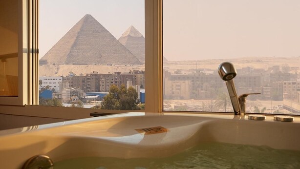 A bathtub with a view of the pyramids.