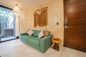 Relax on the sofa amidst a serene view of trees through the sliding glass door.