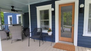 A porch with wicker furniture and a potted plant.