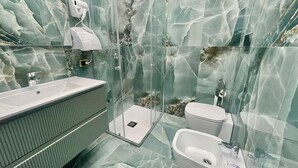 A modern bathroom with a glass-enclosed shower, a sink, a toilet, and a bidet. - At the Naples Binario REGINA ROOM (Napoli)