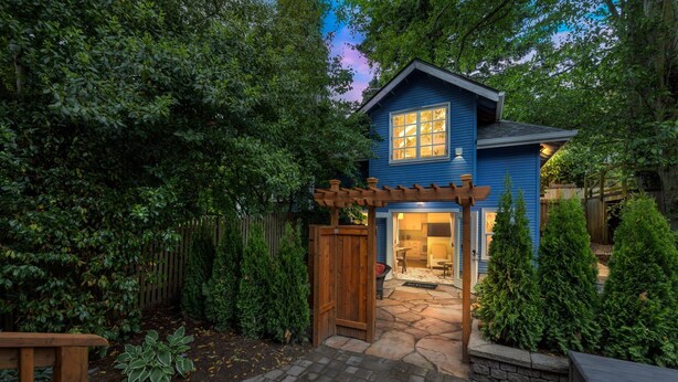A blue house with a stone pathway leading to a wooden gate. - Sunlit Cottage Capitol Hill (Seattle)