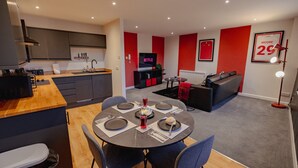 Un apartamento moderno con comedor, cocina, sala de estar y una pequeña cocina auxiliar.