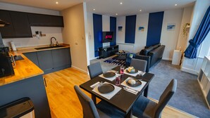 Een modern appartement met keuken, eethoek en woonkamer.