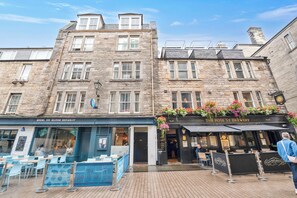 A historic stone building with a restaurant named 'Mussel Inn Seafood Restaurant' and a pub called 'The Rose St Brewery.' - Rose Street flat in the heart of Edinburgh! (Edinburgh)