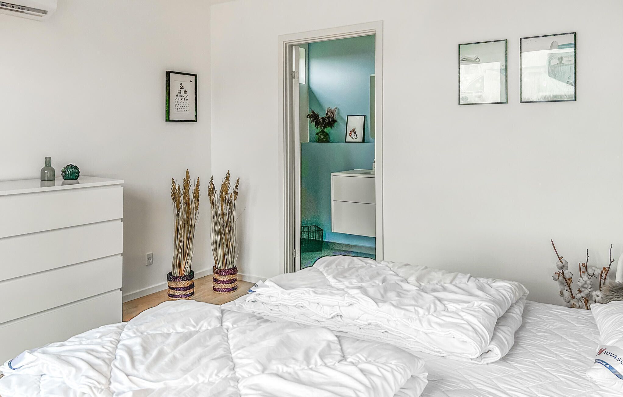 Ein Schlafzimmer mit einem Bett, einem Schminktisch und einer Tür zu einem Badezimmer.