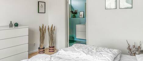 Ein Schlafzimmer mit einem Bett, einem Schminktisch und einer Tür zu einem Badezimmer.