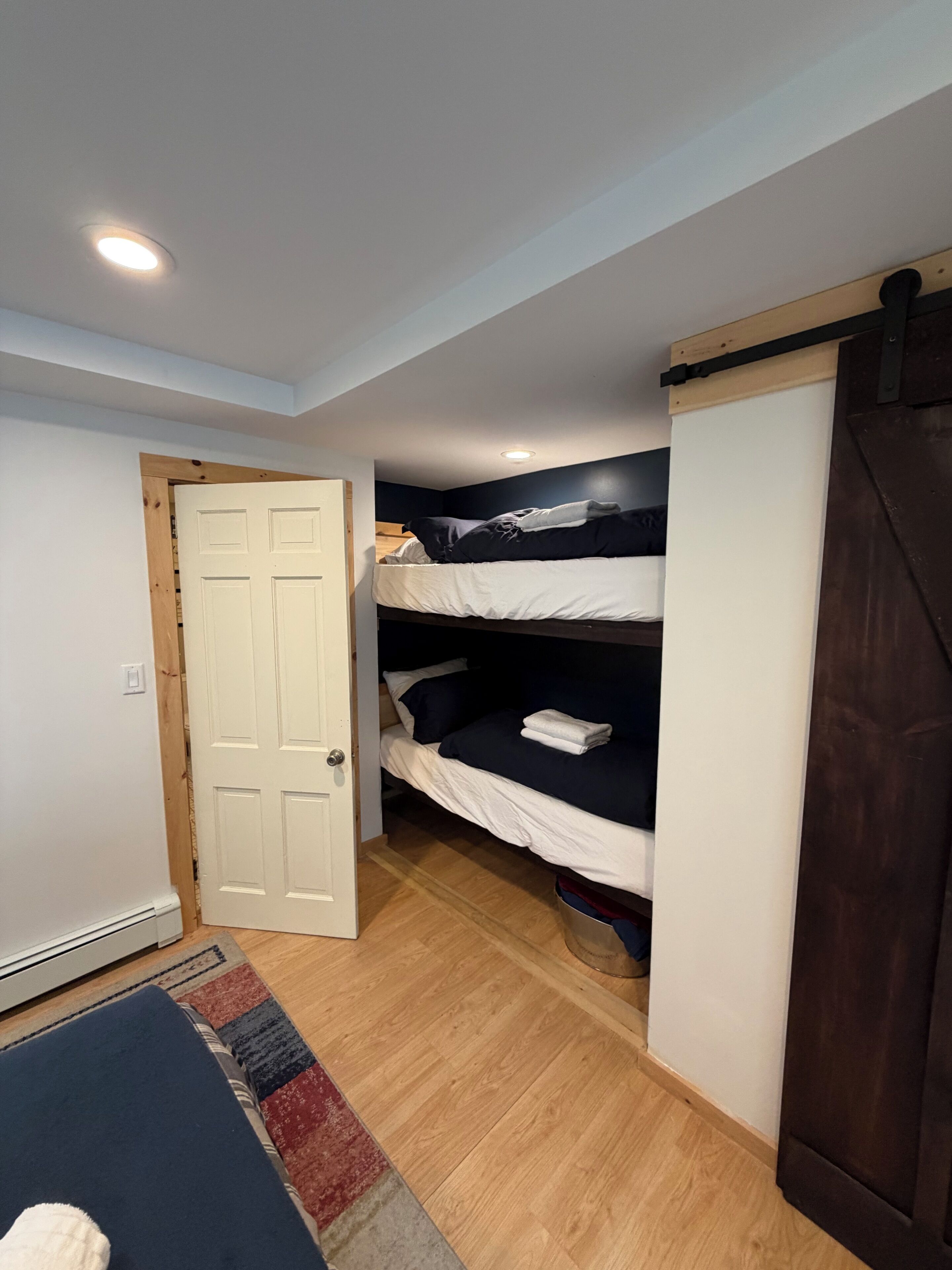 Una habitació amb un llit superposat, una porta corredissa i un radiador.