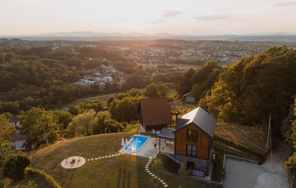 A house with a swimming pool, surrounded by a hilly landscape and a view of a town in the distance. - Lovely home in Stubicke Toplice with sauna (Stubicke Toplice)