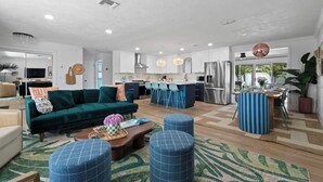 Una sala de estar moderna con un sofá verde, otomanas azules y una mesa de centro.