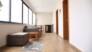 A hallway with a sofa, a small table, and a rug. - Holiday Home 'Casa Do Lagar' with Mountain View, Wi-Fi and Air Conditioning (Agilde)