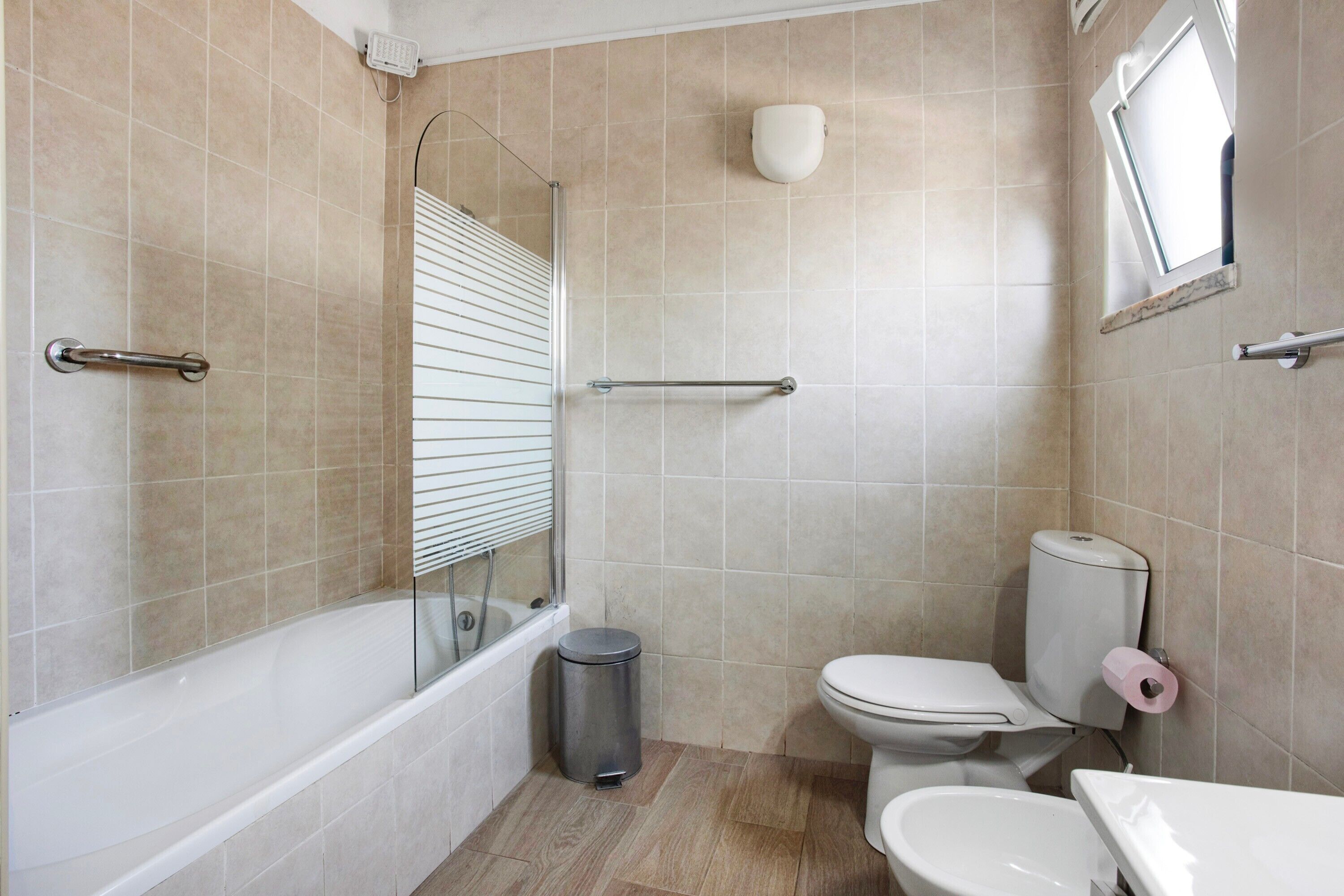 A bathroom with a bathtub, toilet, and bidet.