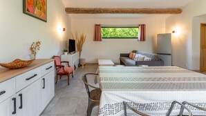 Une pièce comprenant un lit, un bureau, une chaise, un canapé, une fenêtre et une porte.