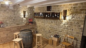 A rustic cellar with stone walls, wooden barrels, and a wine rack. - Ulls del Priorat (El Masroig)