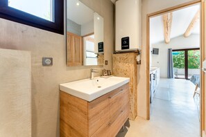 A modern bathroom with a wooden vanity, a large mirror, and a visible shower area. - Cottage 'Saumane, Petite Bergerie' with Private Pool, Wi-Fi and Air Conditioning (Saumane-de-Vaucluse)