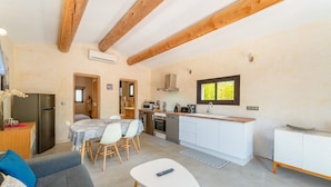 Un espacio habitable compacto con kitchenette, comedor y sofá.