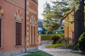 Un bâtiment doté de fenêtres en arc de cercle et d’une entrée fermée par un portail.