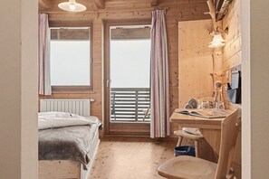A cozy room with a bed, a desk, and a window with curtains. - Room 'Panorama Room 6' with Shared Terrace, Shared Garden and Wi-Fi (Brixen)