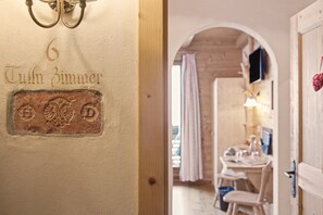 Un passadís amb una porta etiquetada '6 Thulin Zimmer' i una porta de fusta amb una decoració de cor.