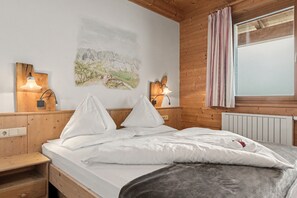 A bed with white linens, two bedside tables with lamps, a painting on the wall, and a window with curtains. - Room 'Panorama Room 6' with Shared Terrace, Shared Garden and Wi-Fi (Brixen)