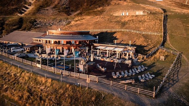 Een terrasrestaurant met zitplaatsen en uitzicht op het omliggende landschap.