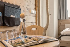 A wooden table with a bottle of rosé, glasses, and a magazine. - Room 'Rossalm Classic' with Shared Terrace, Shared Garden and Wi-Fi (Brixen)