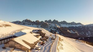 A snow-covered ski resort with buildings, a ski lift, and a mountain backdrop. - Room 'Panorama Room 2' with Shared Terrace, Shared Garden and Wi-Fi (Brixen)