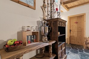 A wooden counter with a coffee maker, a bowl of apples, and tea boxes. - Room 'Four-Poster Bed Room' with Shared Terrace, Shared Garden and Wi-Fi (Brixen)
