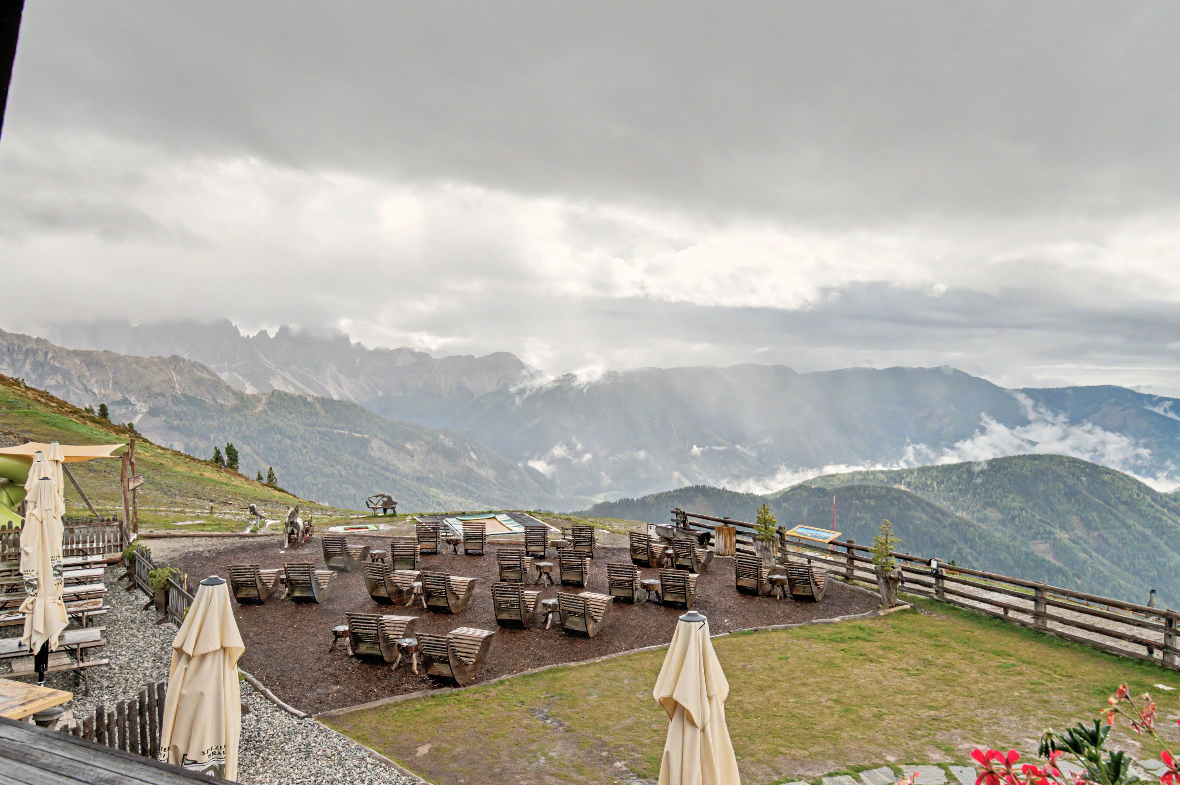A terrace with outdoor seating and a view of mountains.