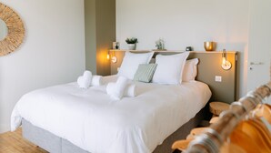 A neatly made bed with white linens, a round mirror on the wall, and two wall-mounted light fixtures. - La Perle, 6 guests, 180° sea view, jacuzzi (Plobannalec-Lesconil)