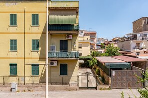 A multi-story building with balconies, a gated entrance, and a clear sky. - Apartment 'Amars House' with Balcony, Wi-Fi and Air Conditioning (Roma)
