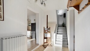 A hallway with a radiator, a wooden bench with notices, and a staircase. - Holiday Home 'Ca' Del Sole' with Sea View, Private Garden and Wi-Fi (Civezza)